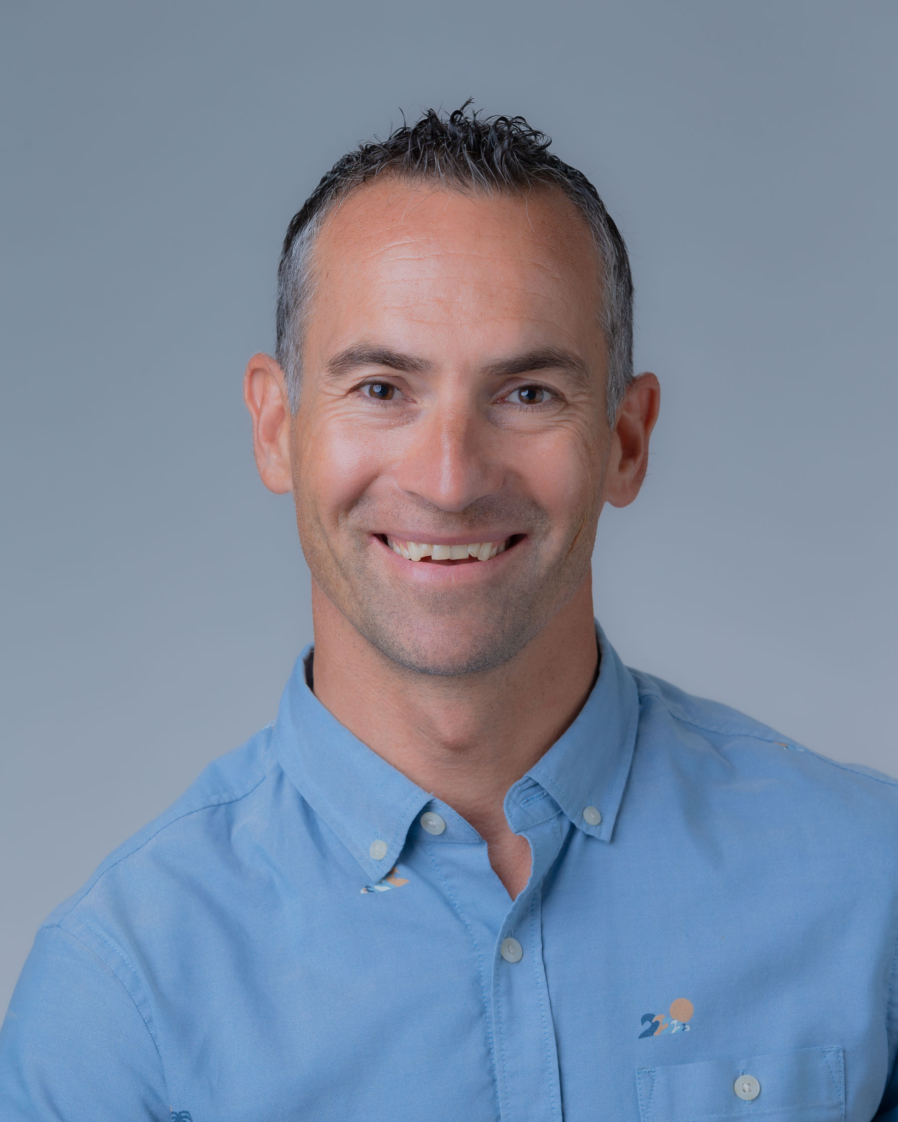 Corporate headshot of an adult male wearing a light blue collared shirt. Headshot of Yovo Stefanov, Business Transformation Office Project Director, DAGS.