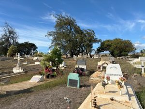 Wide shot of graves and headstones at the Hanapēpē Chinese, Filipino and Portuguese Cemetery on Kauai.